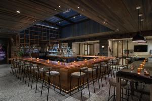 a bar with a bunch of stools in a room at MOXY NYC Times Square in New York