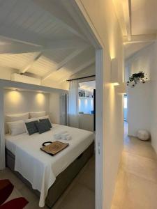 Un dormitorio con una cama blanca y una bandeja. en Appartement 2 chambres en plein cœur de St Jean en Saint Barthelemy