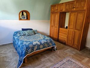 - une chambre avec un lit et une armoire en bois dans l'établissement Casa Espiral, à San Cristóbal de Las Casas