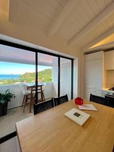 una sala da pranzo con tavolo e vista sull'oceano di Appartement 2 chambres en plein cœur de St Jean a Saint Barthelemy