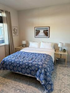 a bedroom with a large bed with a blue and white blanket at Urban SLO Living- 1 mile from downtown in San Luis Obispo