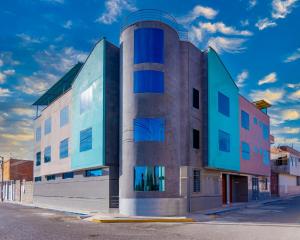 ein Gebäude mit blauen Fenstern auf einer Straße in der Unterkunft HOSTAL TAU TACNA in Tacna