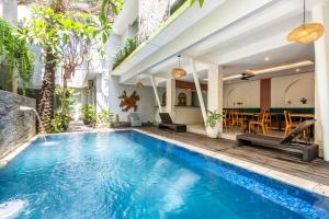an indoor pool with a table and chairs in a building at Casa Dasa Legian in Seminyak