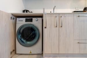 a washing machine in a kitchen next to a counter at Elegant 2 Bed 2 Bath Home in the CBD in Christchurch