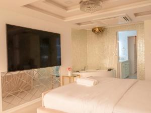 a bedroom with a bed and a tub and a television at Beachfront Seaview Apartment in Male City