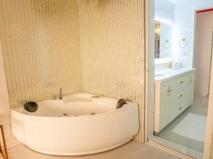 a white bath tub in a bathroom with a sink at Beachfront Seaview Apartment in Male City