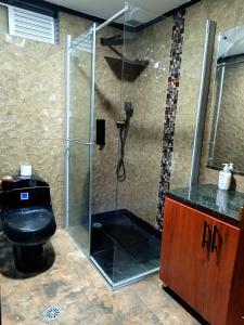 a bathroom with a glass shower with a toilet at LA PAZ! Espacios verdes y zona BBQ in Sogamoso +13 photos