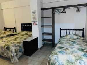 a bedroom with two beds and a bunk bedskirts at Hotel El Kiosco in Acapulco