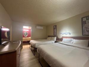 a hotel room with two beds and a flat screen tv at Happy Smart Inn I-10 Eloy and Casa Grande in Eloy