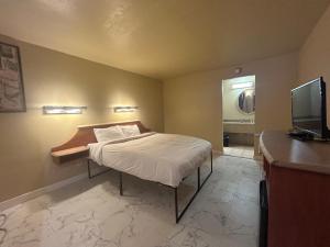 a bedroom with a bed with a television and a desk at Happy Smart Inn I-10 Eloy and Casa Grande in Eloy