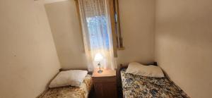two beds in a small room with a window at Casa rustica en Mar Chiquita in Balneario Mar Chiquita