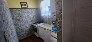 a small kitchen with a sink and a stove at Casa rustica en Mar Chiquita in Balneario Mar Chiquita +12 photos
