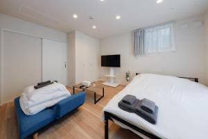 een slaapkamer met een groot bed en een televisie bij La Terrasse Higashikomagata - Vacation STAY 17380v in Tokyo