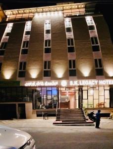 a man standing in front of a large building at S K Legacy Hotel in Mysore