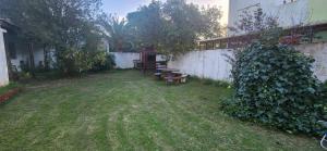 a yard with a table and a bench next to a building at Casa rustica en Mar Chiquita in Balneario Mar Chiquita