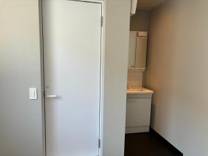 Habitación con puerta a una cocina con encimera en Guesthouse Fujinokura Kawaguchiko Ekimaeten, en Fujikawaguchiko