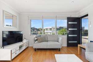 ein Wohnzimmer mit einem TV und einem Sofa in der Unterkunft Applecross Riverside Apt in Perth