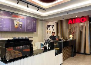 a man standing at the counter of a coffee shop at Airo Hotel Manila in Manila