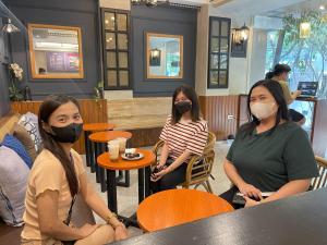 drie vrouwen met maskers in een restaurant bij Airo Hotel Manila in Manilla