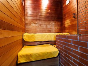 una sauna con 2 camas y una pared de ladrillo en Tabist Hotel Nemuro Kaiyoutei, en Nemuro