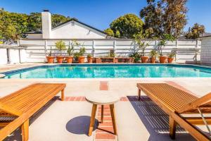 uma piscina com dois bancos e uma mesa em Urban cottage with big pool and great location em Los Angeles