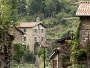 een stenen huis op een heuvel met een straatlicht bij Gîte lumineux avec terrasse et animaux acceptés - FR-1-496-155 in Doizieux