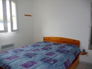 een slaapkamer met een bed met een blauw dekbed bij Villa Le Barcarès, 3 pièces, 6 personnes - FR-1-782-22 in Le Barcarès