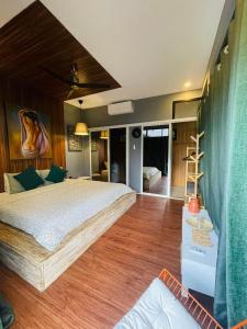 a bedroom with a large bed and wooden floors at Jinjer Resort in Cavinti