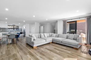 uma sala de estar com um sofá grande e uma cozinha em Urban Oasis - West Auckland Townhouse em Auckland