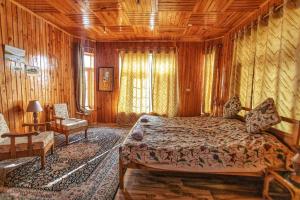 um quarto com uma cama e uma cadeira num quarto em Pahalgam Mir Lidder Lodge on the River em Pahalgam