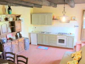 a kitchen with white cabinets and a stove top oven at Splendid Cottage in Vergemoli with Barbecue and Garden in Fornovolasco