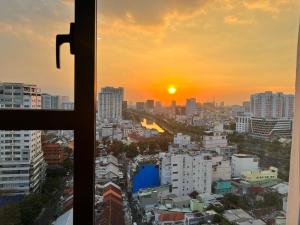 uma vista de uma janela de uma cidade ao pôr-do-sol em Căn hộ Rivergate - Kim's Home em Ho Chi Minh