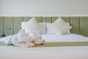 a bed with towels and pillows on it at Mittapan Hotel in Kanchanaburi