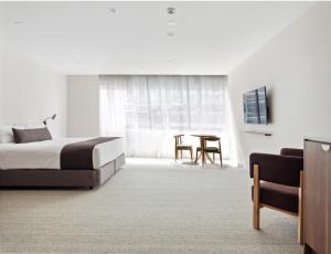 ein Hotelzimmer mit einem Bett und einem Tisch in der Unterkunft Abode Phillip in Canberra