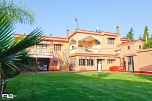 a large house with a lawn in front of it at Gite Karima in Madagh