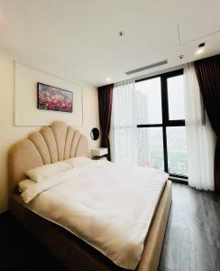 een slaapkamer met een groot bed en een groot raam bij Homestay Oceanpark in Gia Lâm Pho