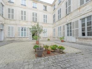un patio con macetas frente a un edificio en Studio La Rochelle, 1 pièce, 2 personnes - FR-1-535-54, en La Rochelle