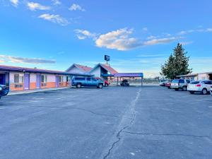 un estacionamiento con autos estacionados frente a un edificio en Rodeway Inn Boardman - Hermiston, en Boardman