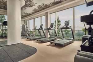 a row of treadmills in a gym with windows at Citadines Science Park Singapore in Singapore