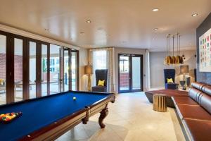 a billiard room with a pool table and a couch at Elite Retro Urban Luxe in Houston