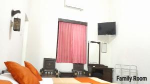a bedroom with a bed and a mirror and a tv at Oryza Hotel Malioboro in Sentool