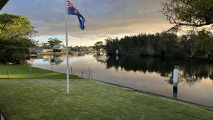 a flag on a pole next to a body of water at A Slice Of Paradise in Sussex Inlet