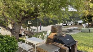 a stack of bricks next to a table and a tree at A Slice Of Paradise in Sussex Inlet