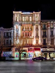 un bâtiment avec une voiture garée devant lui dans l'établissement Hotel Ilisia, à Thessalonique