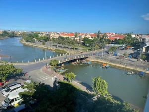 a view of a river with a bridge and cars at River Suites Hoi An in Hoi An