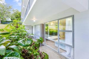 an exterior view of a house with large windows and plants at Herne Bay 1BR Retreat in Auckland