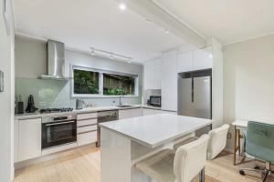 a kitchen with white cabinets and a white counter top at Herne Bay 1BR Retreat in Auckland