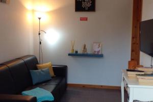 a living room with a black couch and a desk at Caloura Earth Accommodation in Caloura