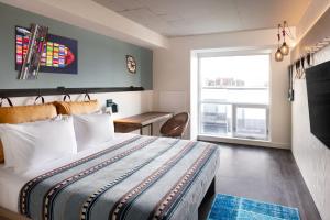 a hotel room with a bed and a window at Moxy Halifax Downtown in Halifax