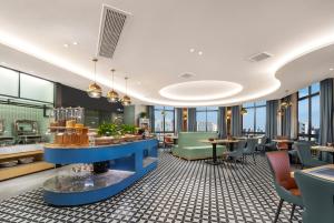 - une vue sur un restaurant avec des tables et des chaises dans l'établissement Mehood Hotel Huangshan High-Speed North Station, à Huangshan